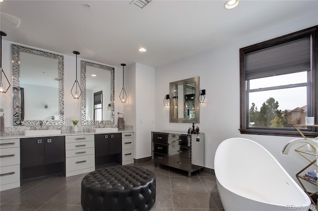 full bath with a soaking tub, two vanities, visible vents, recessed lighting, and a sink