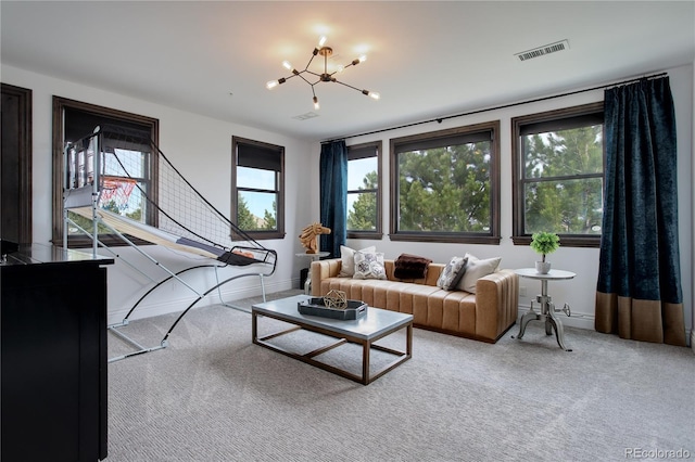 carpeted living area featuring visible vents, baseboards, and a chandelier