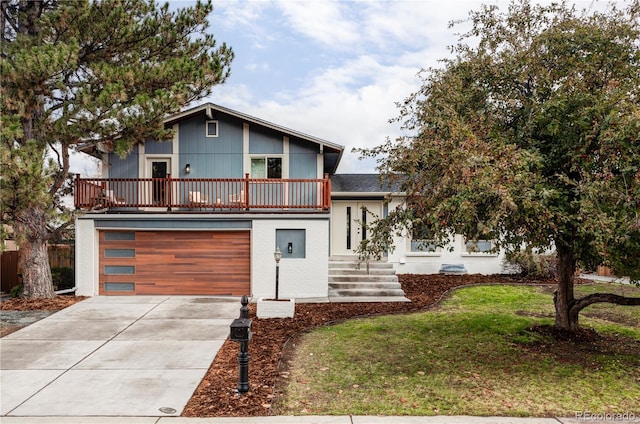 view of front facade with a balcony, a front yard, and a garage