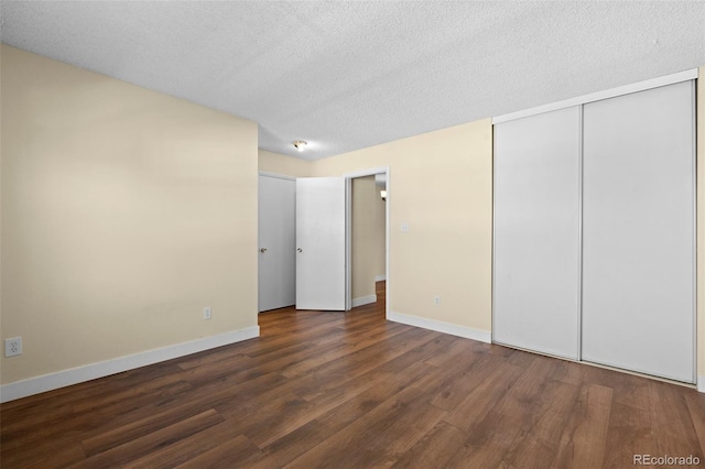 unfurnished bedroom with a closet, dark hardwood / wood-style flooring, and a textured ceiling