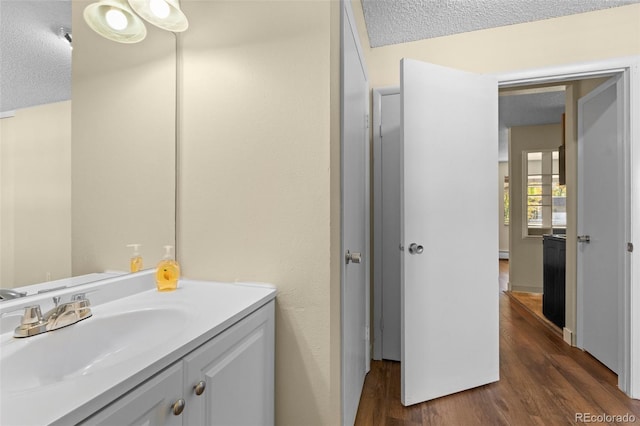 bathroom with vanity, a textured ceiling, and hardwood / wood-style flooring