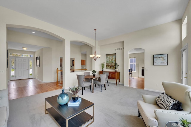 20591 E Weaver Ave, Aurora, CO 80016 - living room with light carpet, arched walkways, and a chandelier