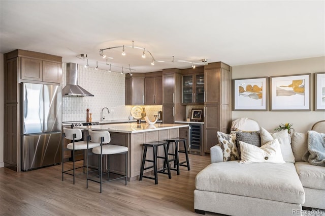 3100 E Cherry Creek S Drive 1403, Denver, CO 80209 - kitchen with stainless steel refrigerator, wall chimney exhaust hood, open floor plan, a breakfast bar, and wine cooler