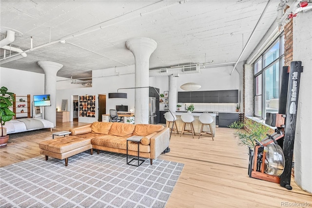 2000 Arapahoe St Unit 503, Denver, CO 80205 - living area featuring decorative columns, wood finished floors, a towering ceiling, and rail lighting