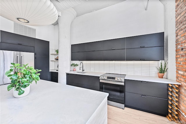 2000 Arapahoe St Unit 503, Denver, CO 80205 - kitchen featuring appliances with stainless steel finishes, modern cabinets, a sink, light countertops, and brick wall