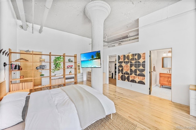 2000 Arapahoe St Unit 503, Denver, CO 80205 - bedroom with wood finished floors, a towering ceiling, ensuite bath, and a sink