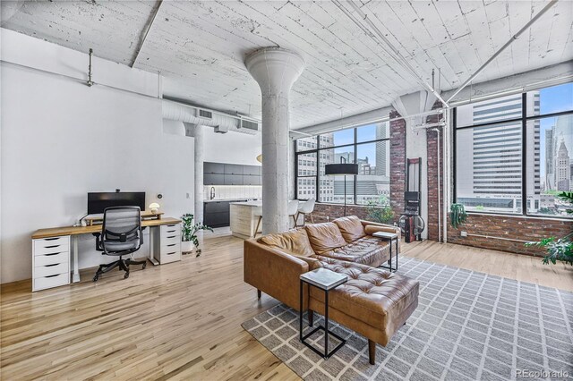 2000 Arapahoe St Unit 503, Denver, CO 80205 - living room with decorative columns, wood finished floors, an office area, and healthy amount of natural light