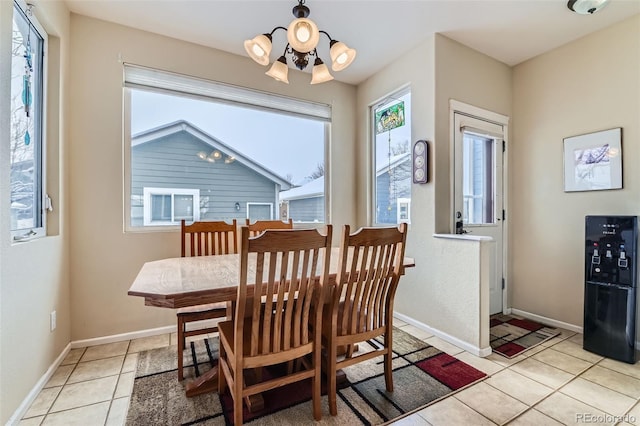 tiled dining room featuring an inviting chandelier