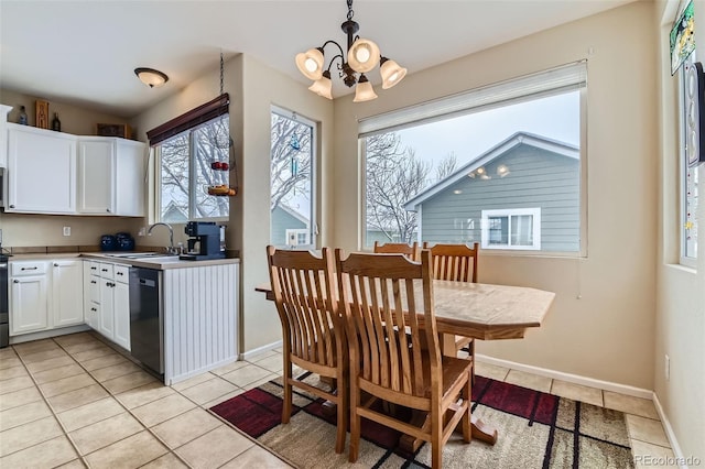 kitchen with sink, white cabinetry, hanging light fixtures, light tile patterned floors, and appliances with stainless steel finishes