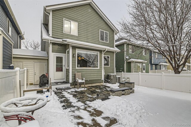 snow covered property featuring central AC