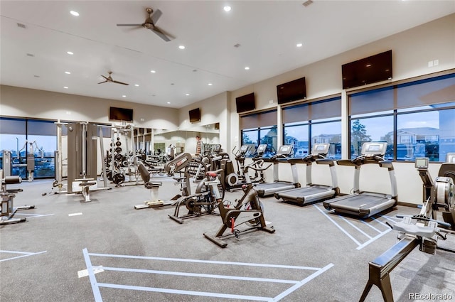 exercise room featuring ceiling fan and a towering ceiling