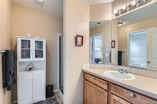 bathroom featuring vanity, tile patterned flooring, and plus walk in shower