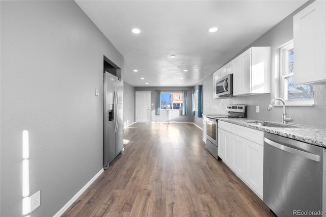 kitchen with light stone countertops, sink, stainless steel appliances, dark hardwood / wood-style flooring, and white cabinets