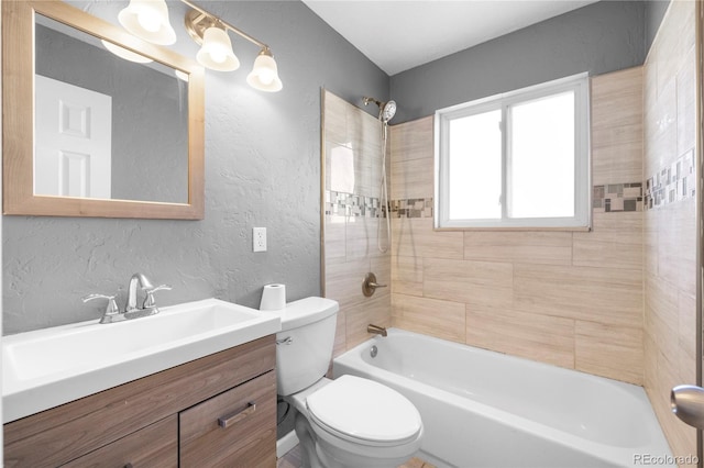 full bathroom with vanity, tiled shower / bath combo, and toilet