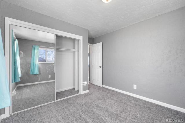 unfurnished bedroom featuring carpet, a textured ceiling, and a closet