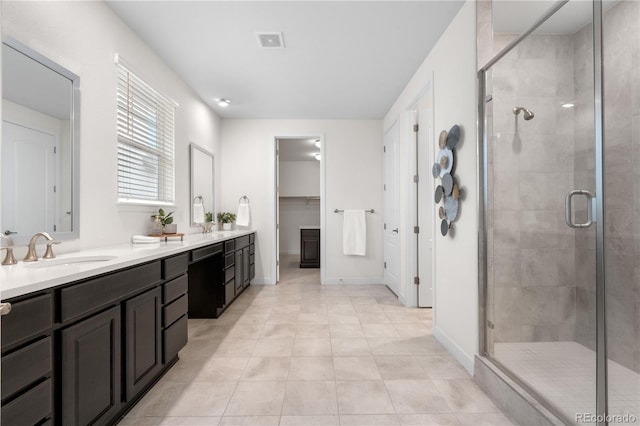 8814 S Winnipeg Ct, Aurora, CO 80016 - full bathroom featuring double vanity, a shower stall, tile patterned flooring, and a walk in closet
