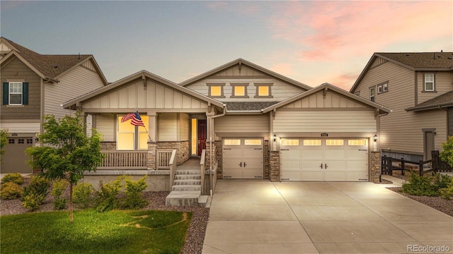 8814 S Winnipeg Ct, Aurora, CO 80016 - craftsman-style home featuring board and batten siding, covered porch, driveway, and stone siding