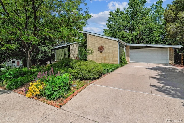 9113 E Evans Way, Denver, CO 80231 - mid-century home featuring brick siding, driveway, and a garage