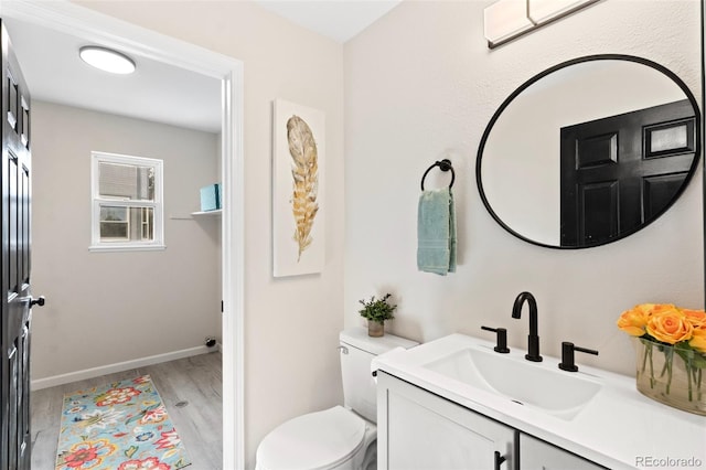 bathroom featuring vanity, hardwood / wood-style flooring, and toilet