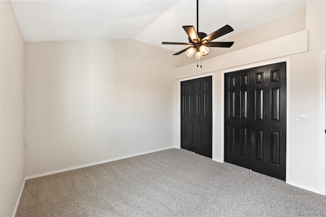 unfurnished bedroom featuring carpet flooring, multiple closets, ceiling fan, and vaulted ceiling