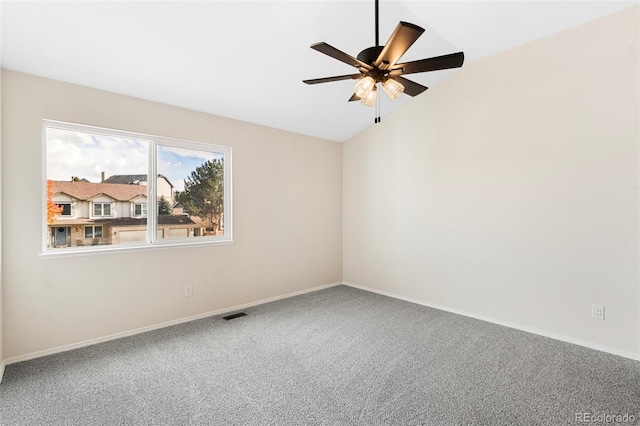 spare room featuring carpet floors, vaulted ceiling, and ceiling fan