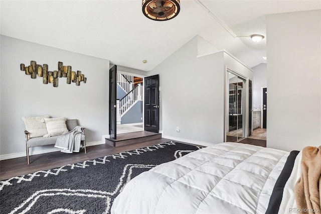 bedroom with baseboards, vaulted ceiling, and wood finished floors