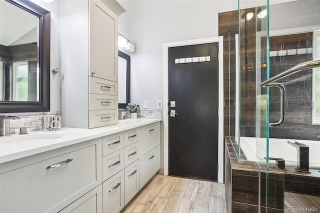 full bath featuring a sink, backsplash, and double vanity