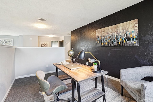 office area featuring visible vents, a textured ceiling, baseboards, and carpet