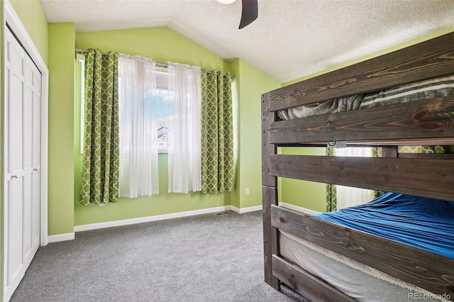 bedroom with a ceiling fan, a textured ceiling, baseboards, lofted ceiling, and carpet flooring