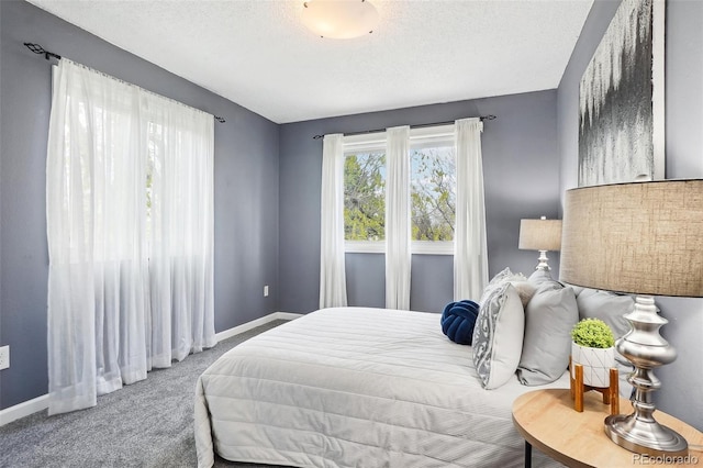 bedroom featuring carpet flooring, a textured ceiling, and baseboards