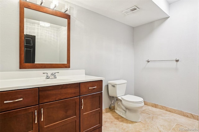 bathroom featuring visible vents, vanity, toilet, baseboards, and tile patterned floors