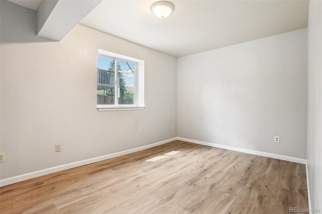 unfurnished room with baseboards and wood finished floors