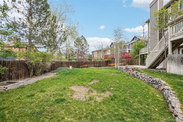 view of yard featuring a fenced backyard and stairway