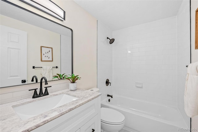 full bathroom with tiled shower / bath, vanity, and toilet