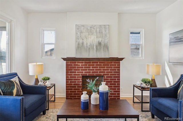 living room with a healthy amount of sunlight, baseboards, a fireplace, and wood finished floors