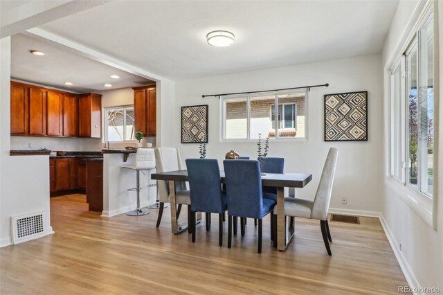 dining space featuring light wood-style floors, baseboards, recessed lighting, and visible vents