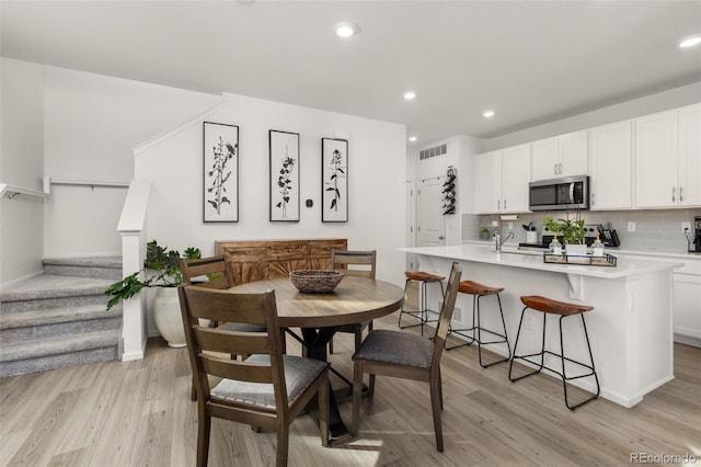 dining room featuring sink and light wood-type flooring