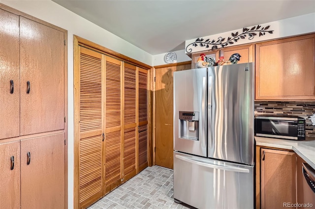 6436 Otis St, Arvada, CO 80003 - kitchen with stainless steel appliances, light countertops, decorative backsplash, and brick patterned floors