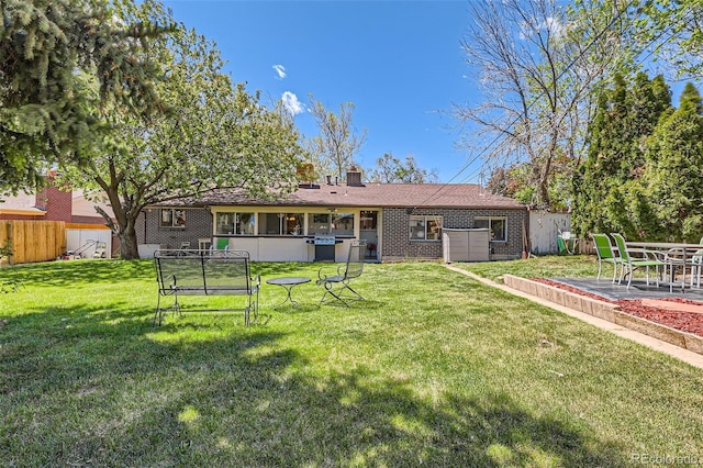 6436 Otis St, Arvada, CO 80003 - rear view of house featuring brick siding, a patio area, and a chimney