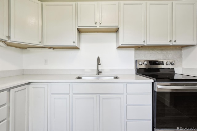 180 S Lamar St, Lakewood, CO 80226 - kitchen with stainless steel electric stove, a sink, light countertops, and white cabinets