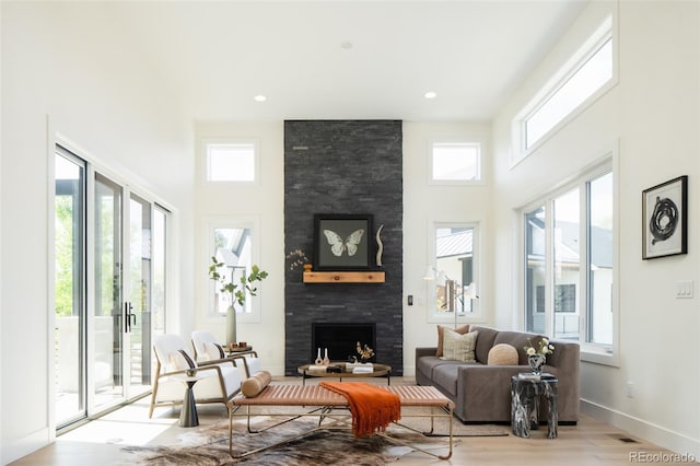 8230 W Tennessee Ct, Lakewood, CO 80226 - living room featuring a large fireplace, plenty of natural light, a high ceiling, wood finished floors, and baseboards