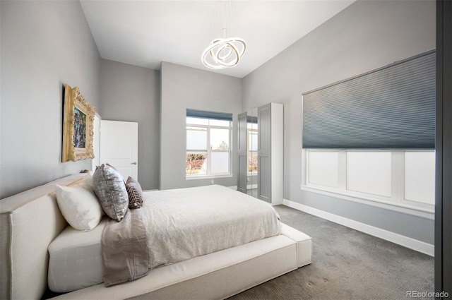 bedroom with baseboards, a notable chandelier, and carpet