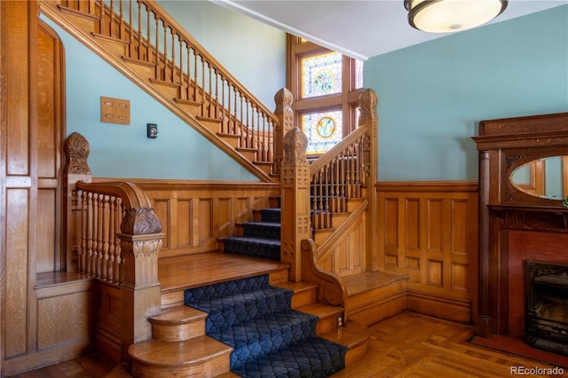 stairs featuring a wainscoted wall