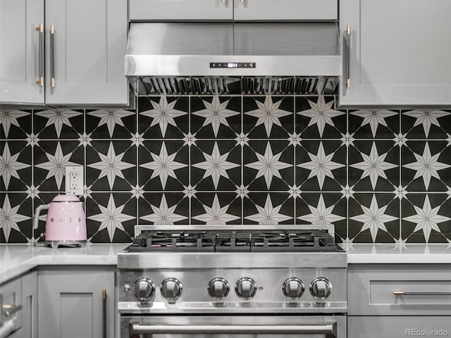 details with tasteful backsplash, stainless steel stove, light countertops, and extractor fan