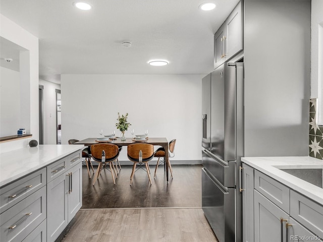 kitchen featuring stainless steel refrigerator with ice dispenser, gray cabinetry, and light wood finished floors