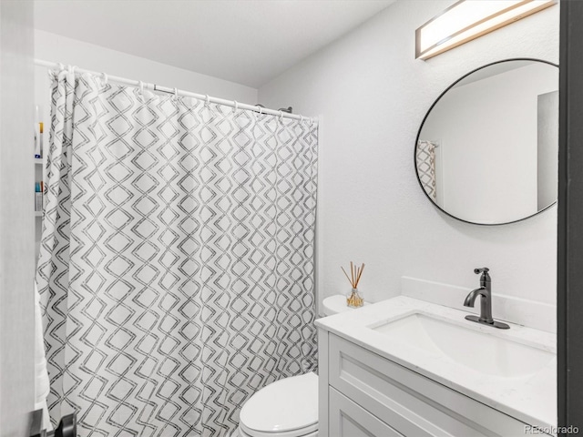 bathroom featuring a shower with shower curtain, vanity, and toilet