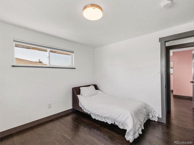 bedroom with baseboards and wood finished floors