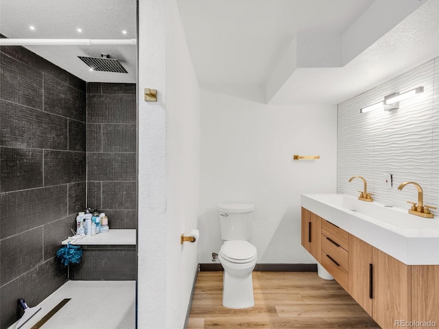 full bathroom with a walk in shower, baseboards, toilet, and wood finished floors