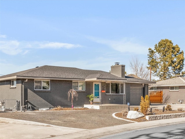 ranch-style home featuring brick siding, fence, a chimney, and an attached garage