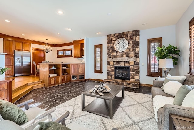 living room featuring a notable chandelier and a stone fireplace